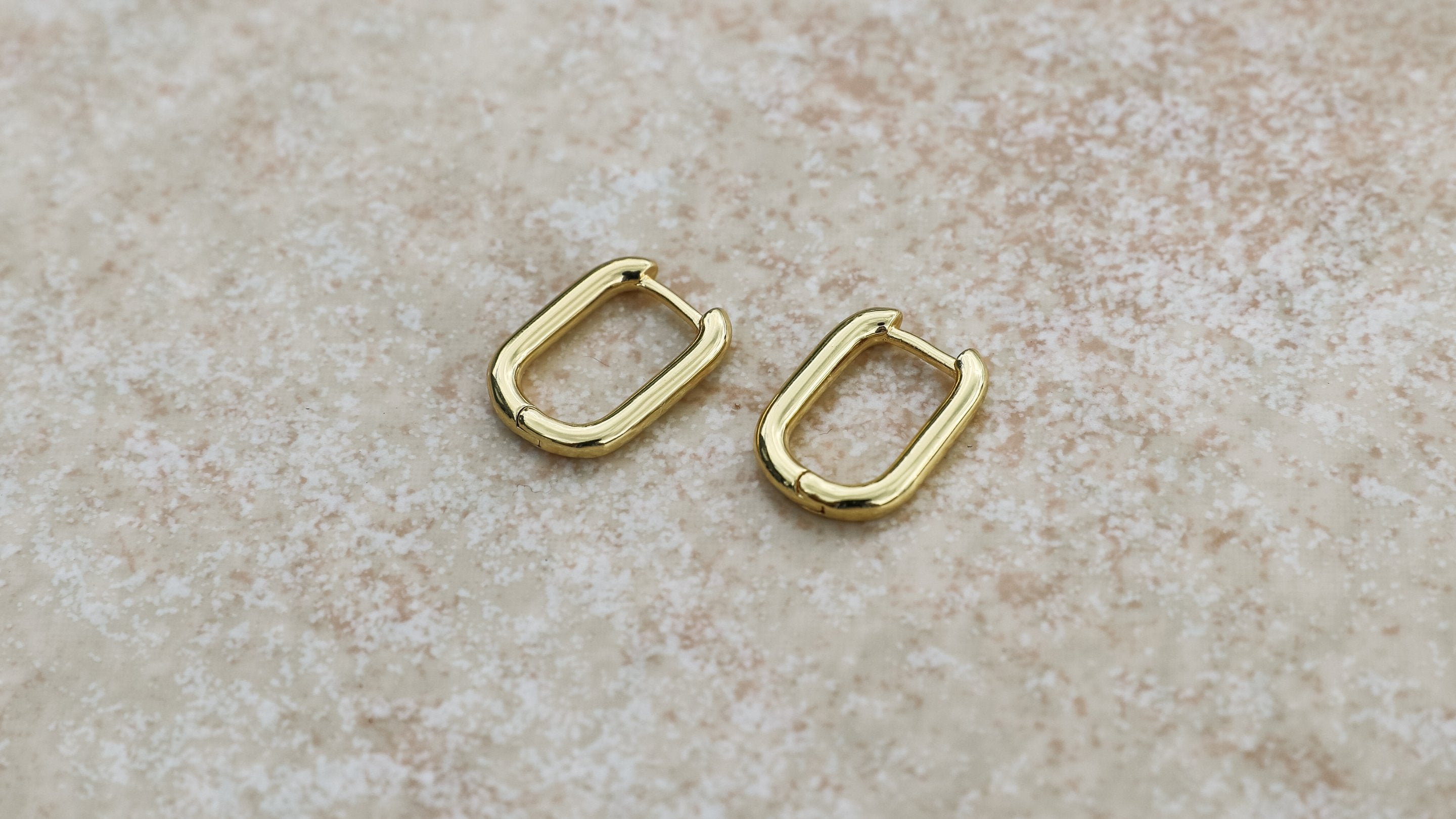 gold hoop earrings on stone