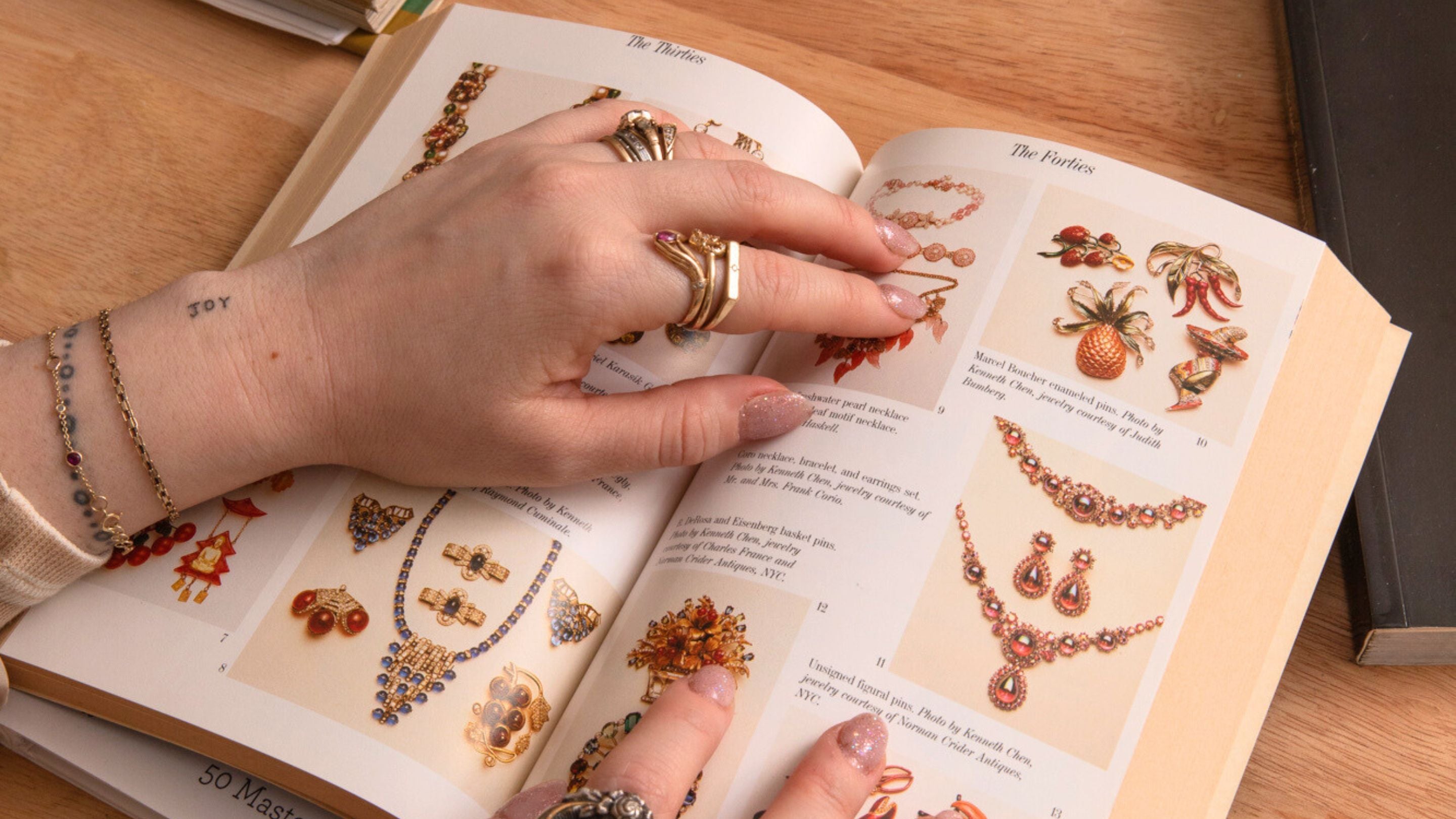 kat's hands with rings on jewelry book